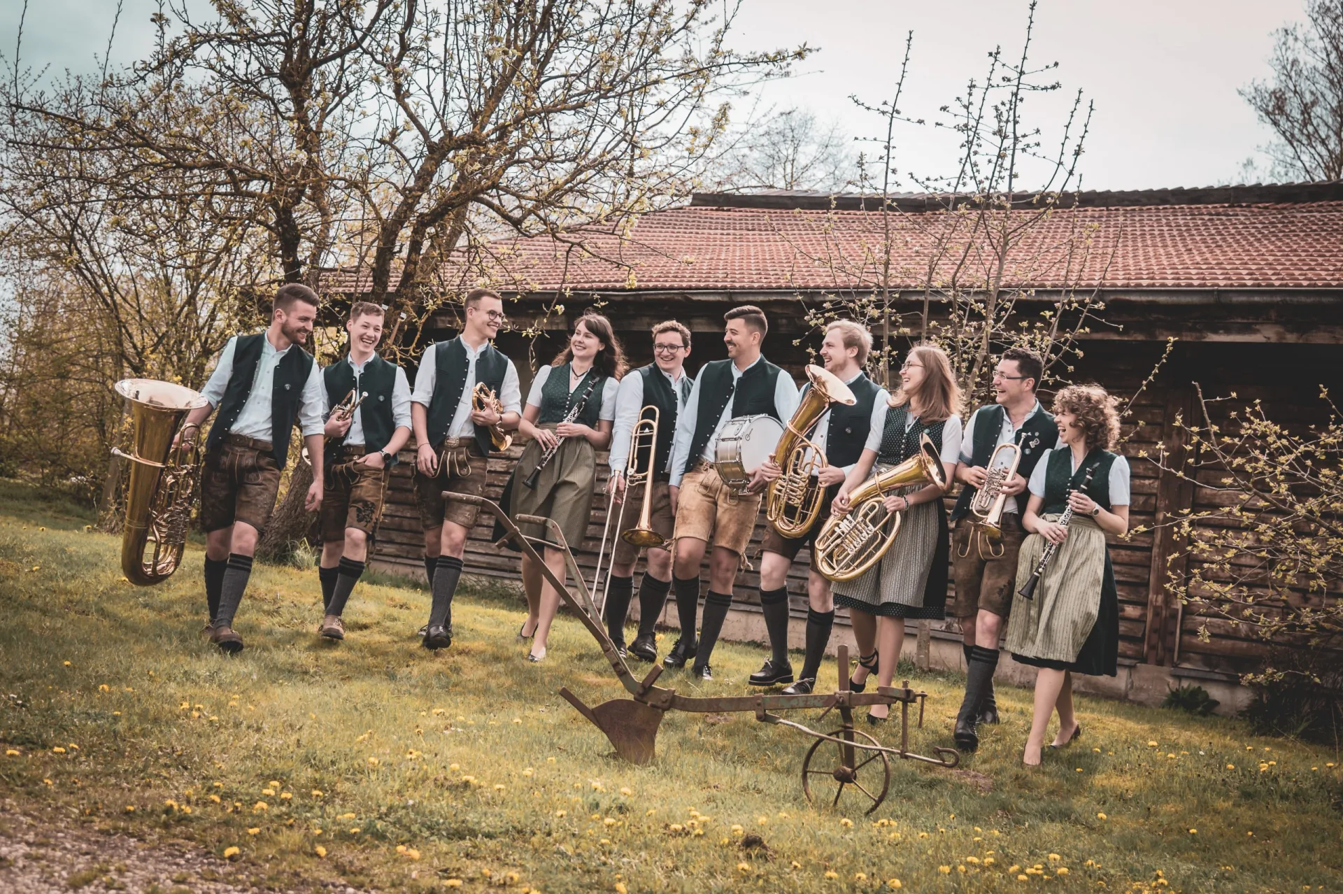 Die Blechschinda mit ihren Instrumenten vor einem alten Holzstadl